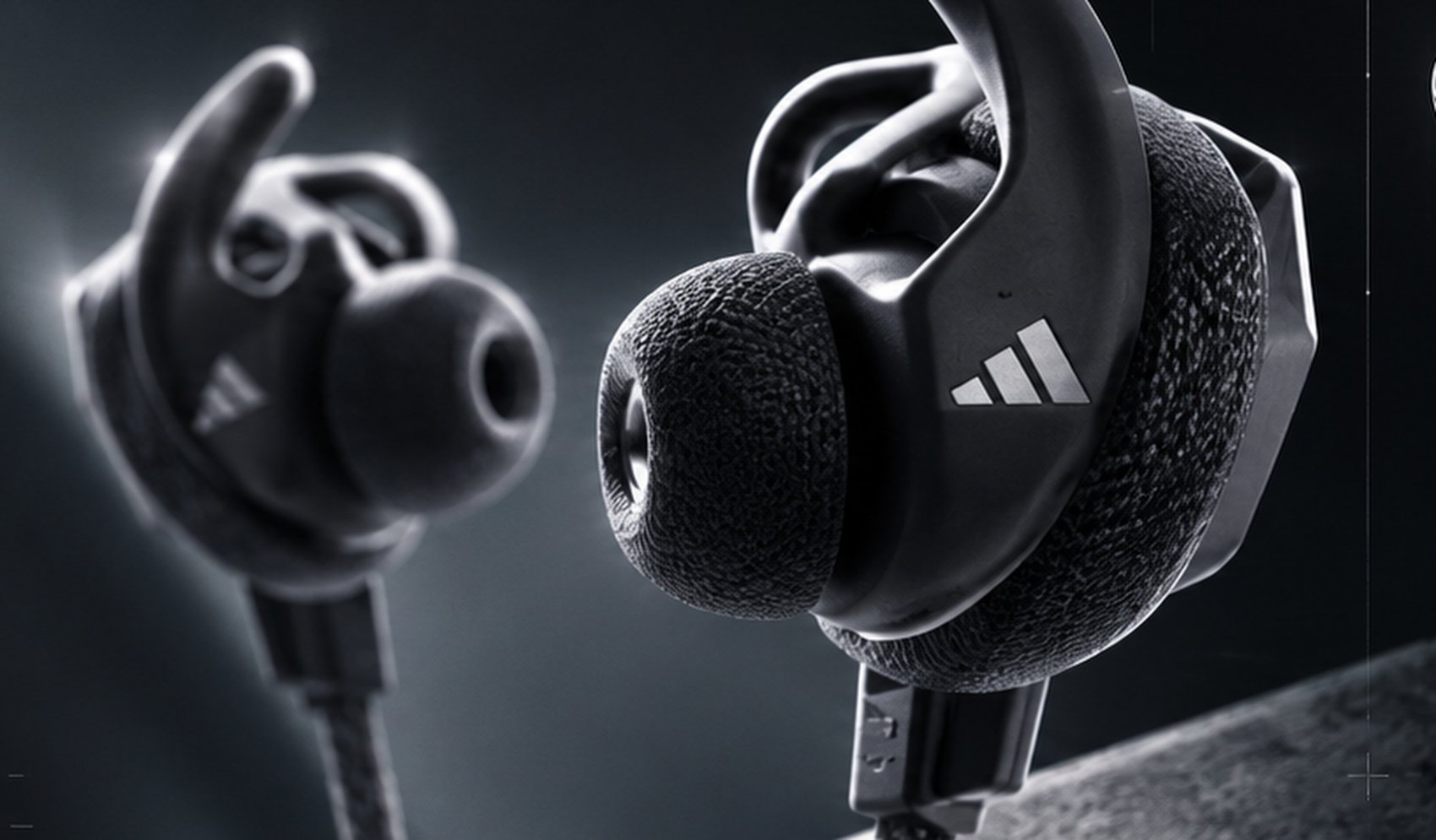 A technical key-line diagram of adidas wireless sport earbuds, with instructional callouts showing how to fold the textile back over the ear cushion, use the multi-directional control jog to adjust volume, and details on all-day sweat resistance.