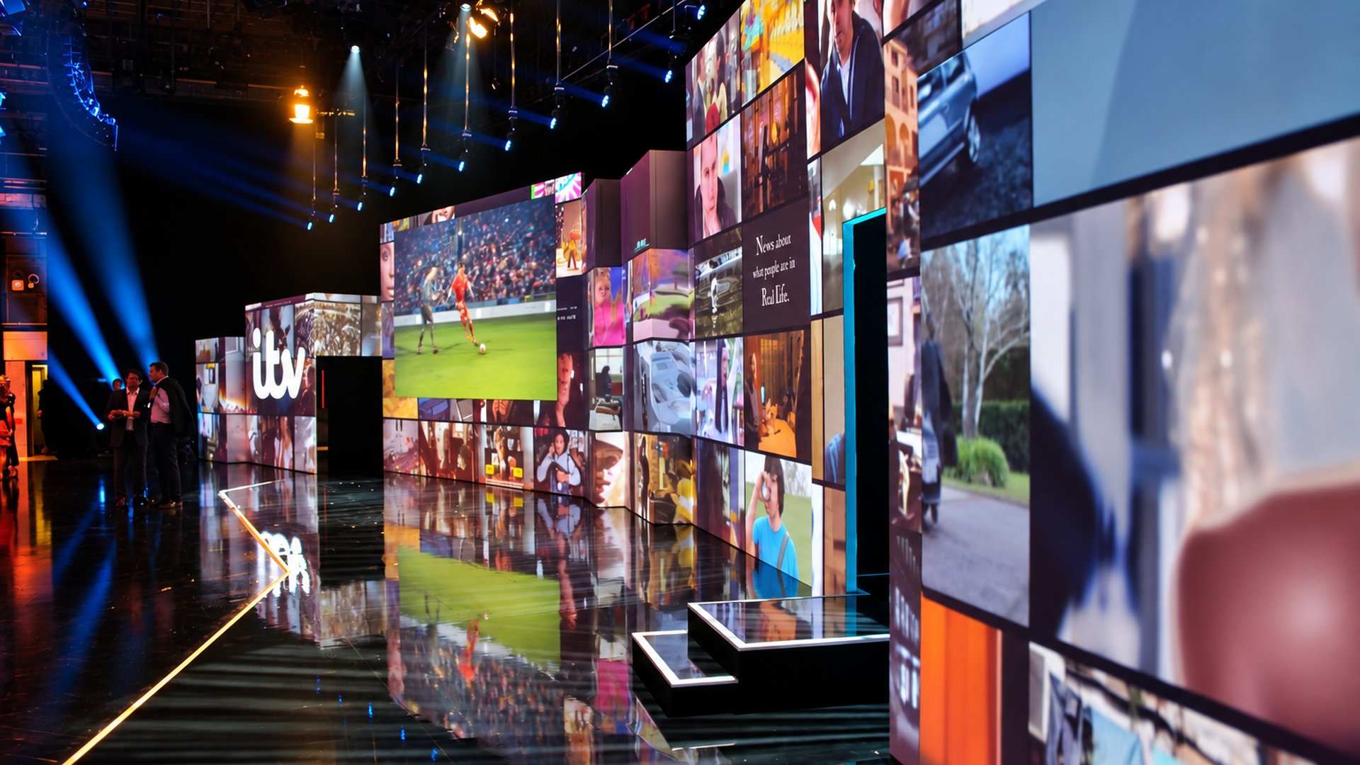 ITV Upfronts stage screens showing a wall of programme footage, with a presenter walking past the ITV ident.